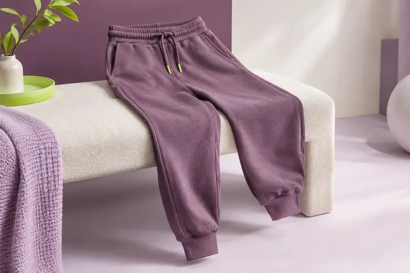 Pantalon de jogging de sport posé sur un banc clair