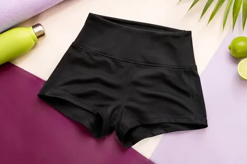 Shorty de sport noir à taille haute, coupe courte et ajustée, posé sur un fond de studio lumineux.