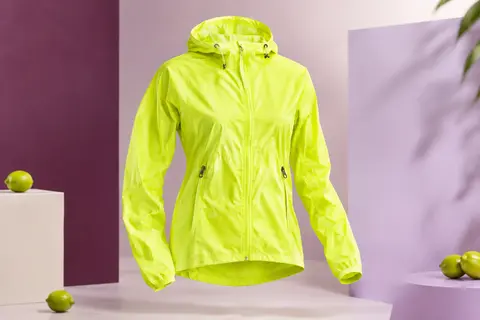 Veste de cyclisme jaune fluorescent à capuche et poches zippées, présentée seule sur fond de studio clair.