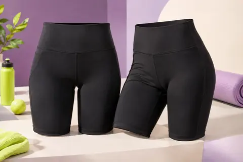 Deux shorts de cyclisme noirs à taille haute, en tissu uni extensible, posés sur un fond clair.