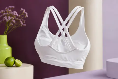 Brassière de sport blanche sans armature, avec dos croisé et coussinets amovibles.