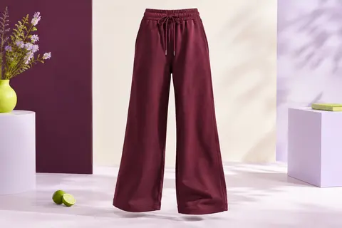 Pantalon de jogging bordeaux à jambe large, taille élastique et cordon de serrage, posé en studio lumineux.