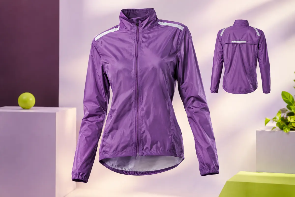Veste de cyclisme violette avec capuche rangée dans le col et bandes réfléchissantes aux épaules et au dos.