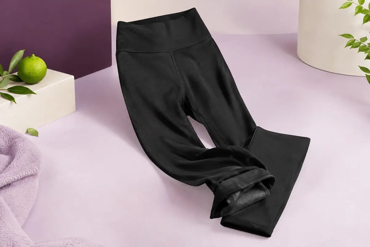 Legging de sport noir à taille haute, avec un pli montrant sa doublure polaire douce.