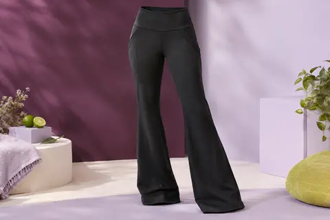 Pantalon de yoga noir bootcut à taille haute et quatre poches, présenté seul dans un studio clair.