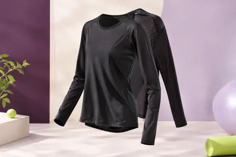 Tee-shirt de sport noir à manches longues avec col rond et panneau en maille au dos, présenté en studio.